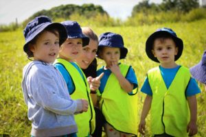 Childcare educator with children in field during Bush Kindy at Suncoasst Little Learners