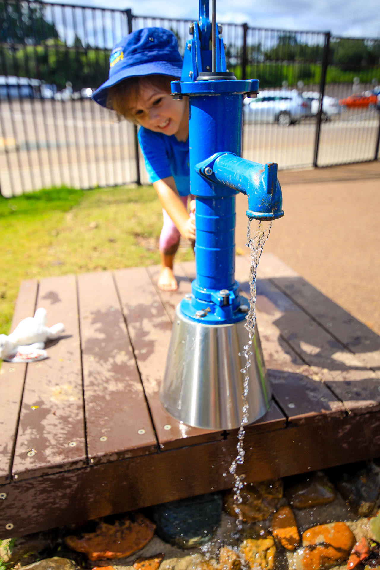 Pre-school Kindergarten child playing with water pump at Suncoast Little Learners