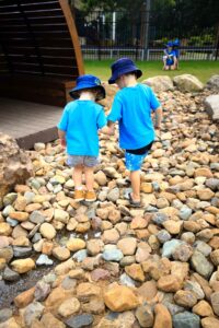 Pre-school Kindergarten children playing in rocky garden at Suncoast Little Learners