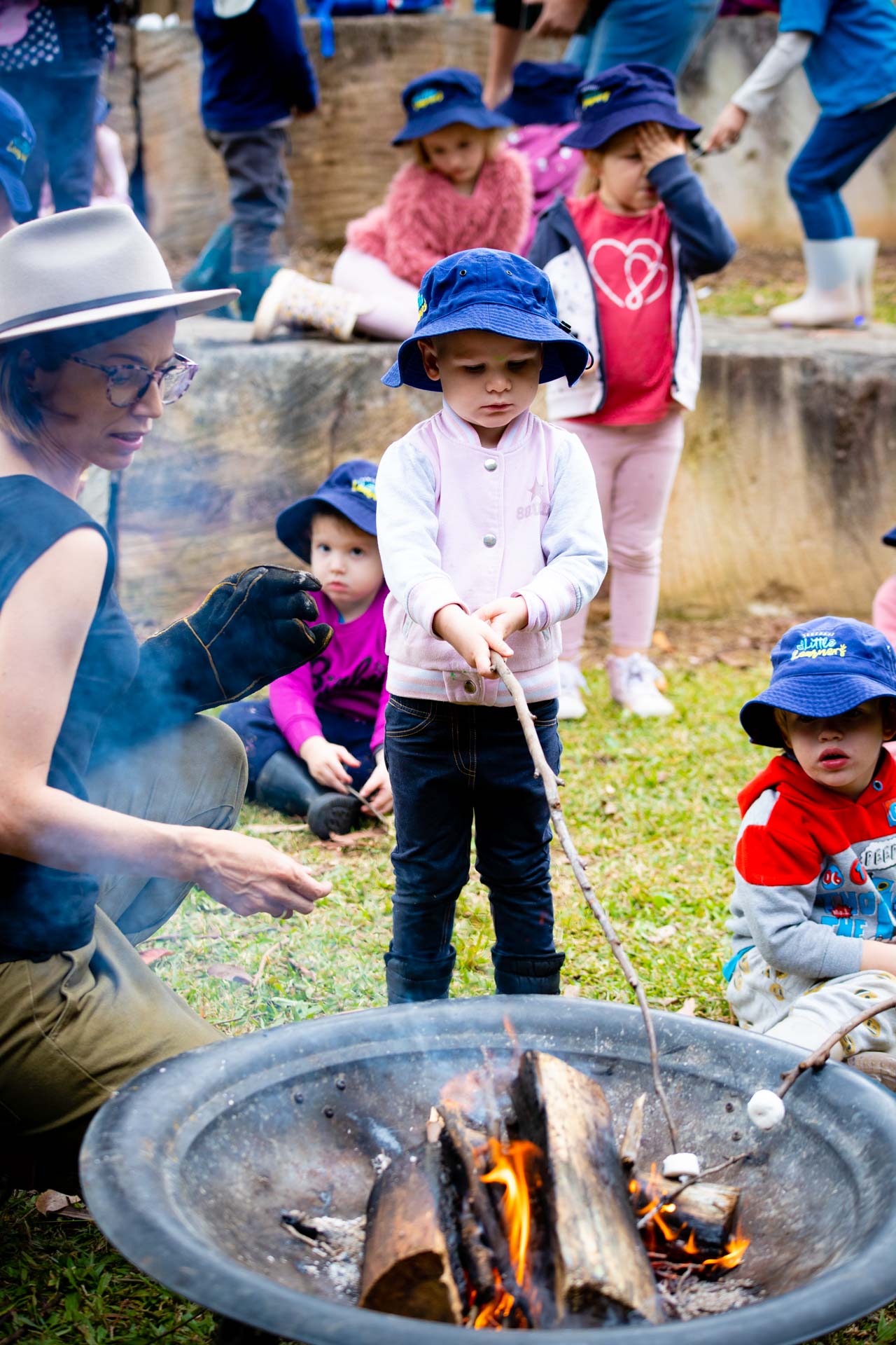 Bush Kindy - Pre School Kindergarten student roasting marshmallows over fire. Sunshine Coast